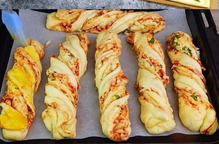 Blätterteigstangen mit Schinken und Käse auf einem Teller angerichtet