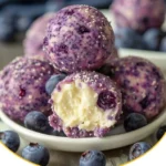 Cremige Blaubeer-Käsekuchen-Protein-Energie-Bällchen auf einem Teller