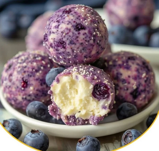 Cremige Blaubeer-Käsekuchen-Protein-Energie-Bällchen auf einem Teller