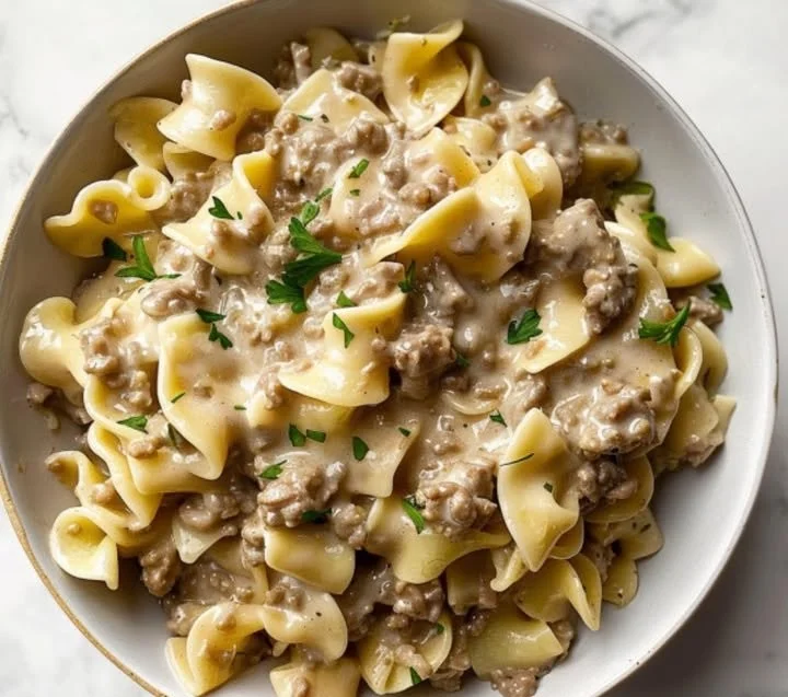 Cremige Hackfleisch-Pasta mit Schleifennudeln auf einem Teller serviert
