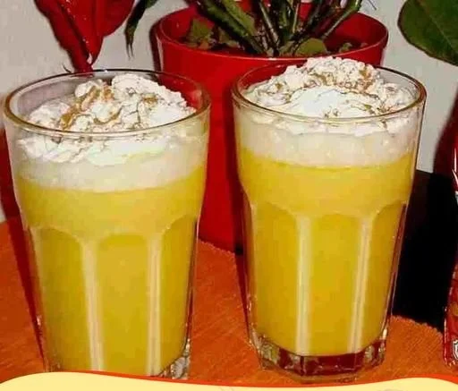 Eierpunsch in einer Tasse, beleuchtet im Weihnachtsmarkt-Ambiente