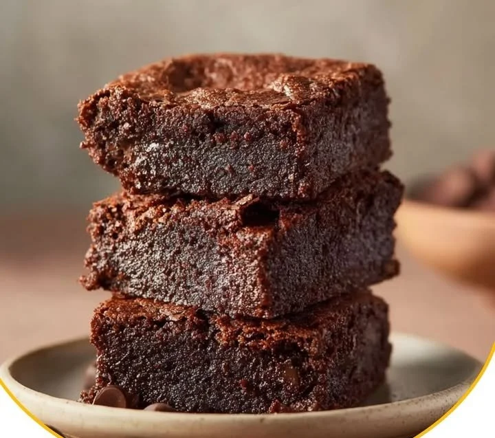 Hüttenkäse-Protein-Brownies auf einem Holzbrett dekoriert mit Schokolade