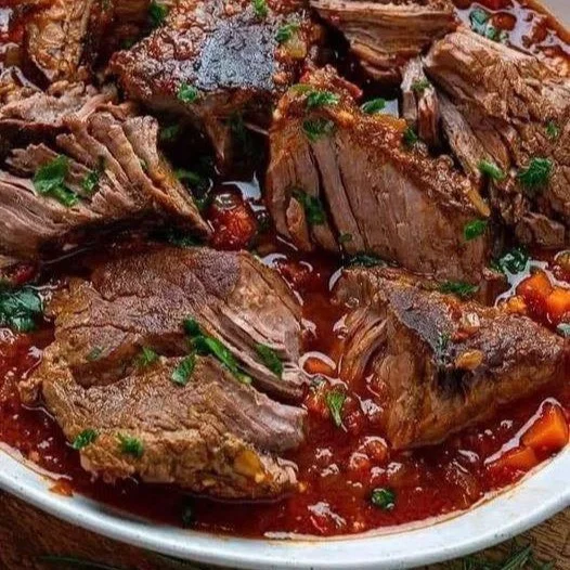 Italienischer Schmorbraten mit Knoblauch, serviert auf einem rustikalen Tisch.