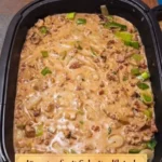 Jägertopf Gericht mit Pilzen, Fleisch und frischen Kräutern auf einem Teller serviert.