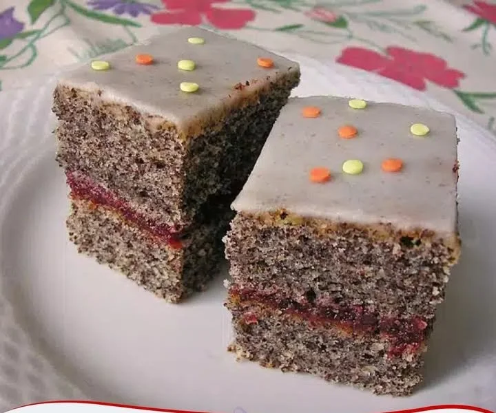 Joghurt-Mohnkuchen auf einem Teller, garniert mit Mohn und frischen Früchten.