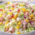 Bunter Salat mit frischem Gemüse und Dressing auf einem Teller.