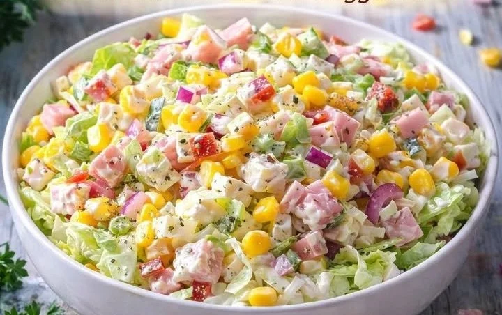 Bunter Salat mit frischem Gemüse und Dressing auf einem Teller.