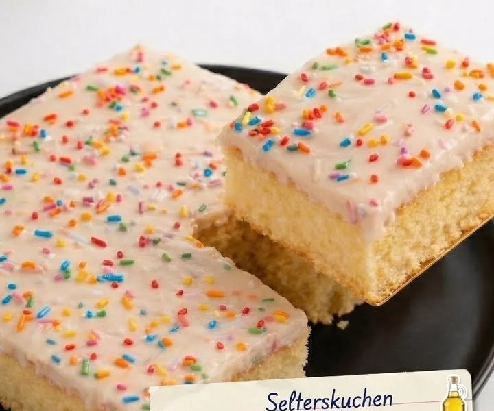 Selterskuchen auf einem Teller, serviert mit frischem Obst und Sahne.