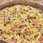 Ein Teller frisch zubereiteter Spaghettisalat mit buntem Gemüse.
