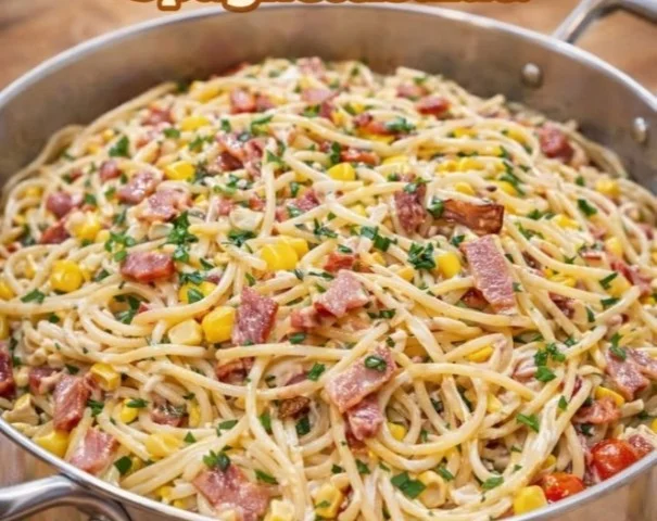 Ein Teller frisch zubereiteter Spaghettisalat mit buntem Gemüse.