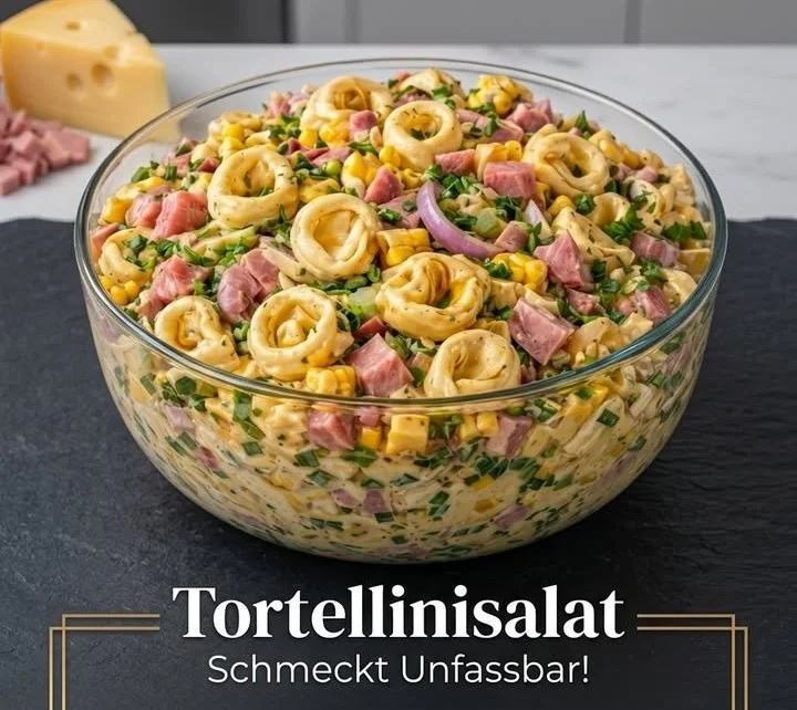 Bunter Tortellinisalat mit frischem Gemüse und Dressing in einer Schüssel