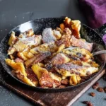 Fluffiger Kaiserschmarrn von Altbaerlis, serviert mit Puderzucker und Apfelmus.