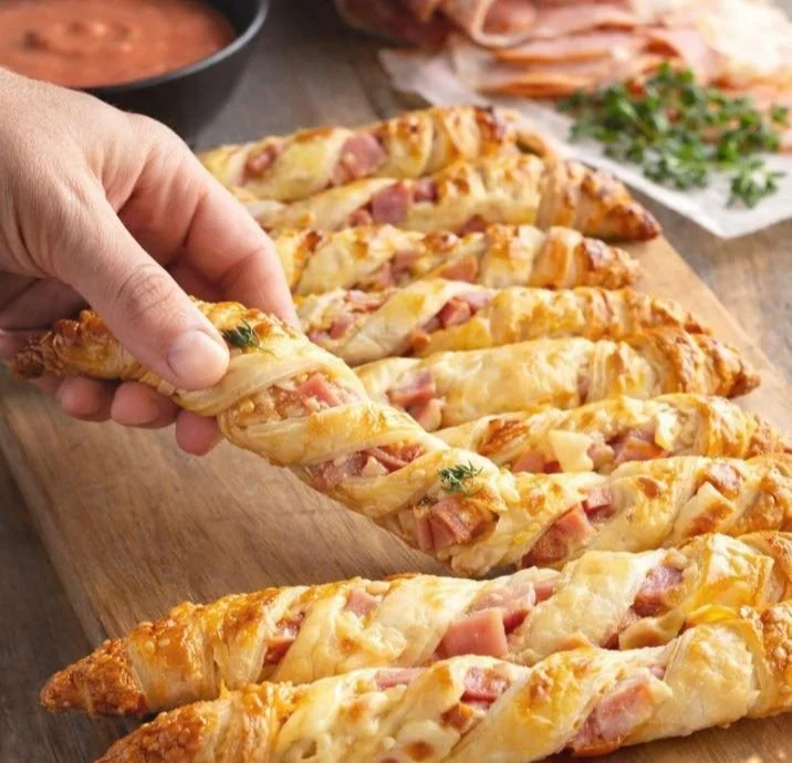 Blätterteig Stangen gefüllt mit Schinken und Käse auf einem Teller