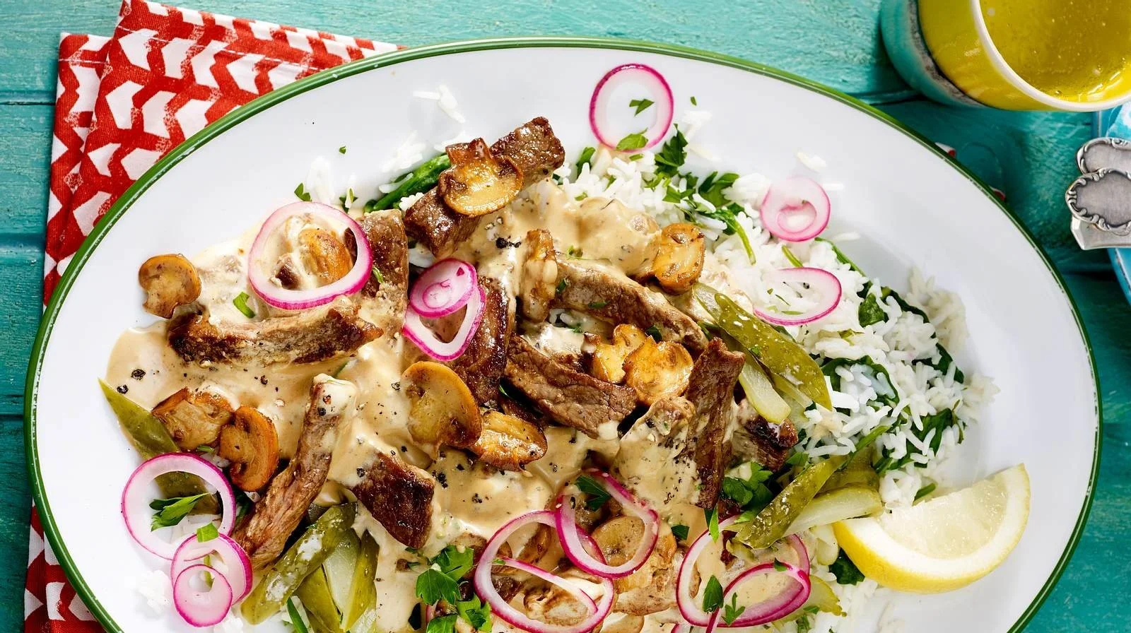 Blitz-Rindfleisch-Stroganoff serviert auf Spinatreis mit frischem Gemüse