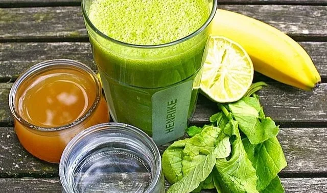 Grüner Frühstücks-Smoothie mit frischen Zutaten im Glas