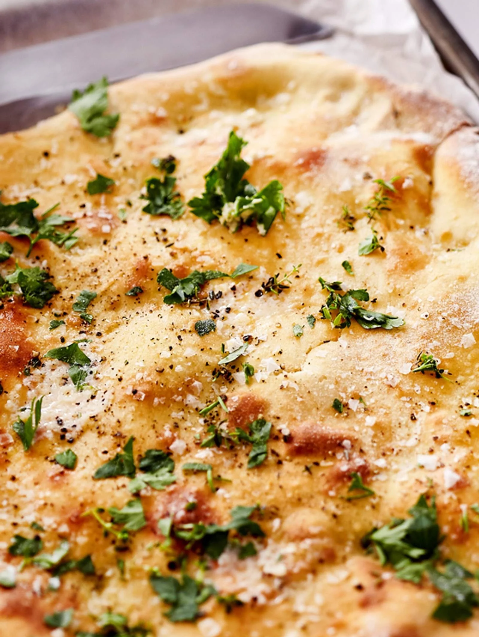Frisch gebackenes Herb Naan Bread aus dem Ofen mit Kräutern