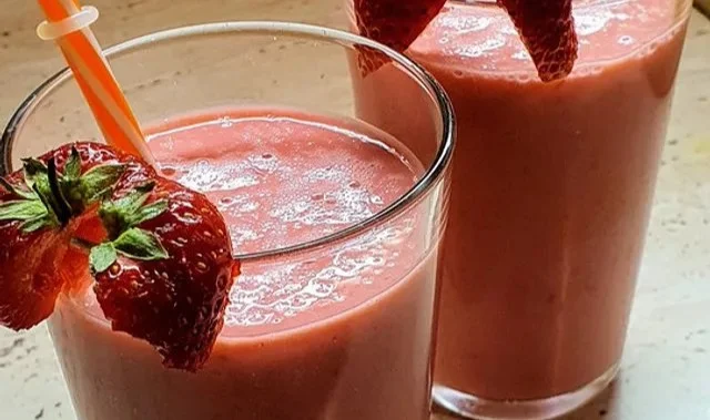 Himbeer-Orange-Smoothie in einem Glas mit frischen Himbeeren und Orangenstücken