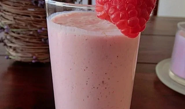 Erfrischender Himbeeren Smoothie in einem Glas mit Himbeeren und Minze