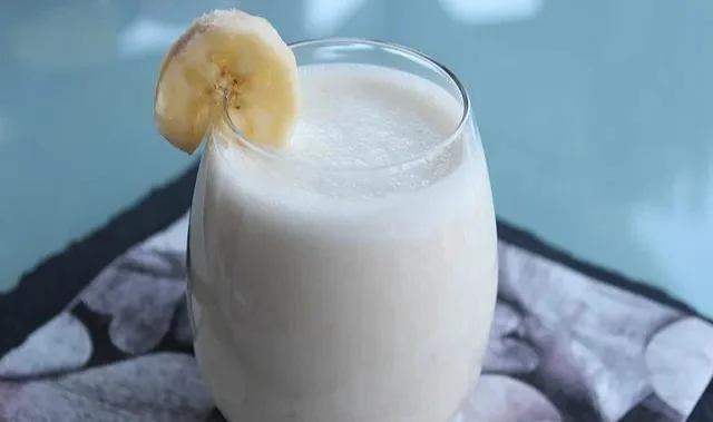 Erfrischender Joghurt-Bananen-Milchshake in einem Glas mit Banane und Joghurt