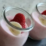 Leckerer Joghurt Frühstücks-Smoothie in einem Glas mit frischen Früchten und Haferflocken.