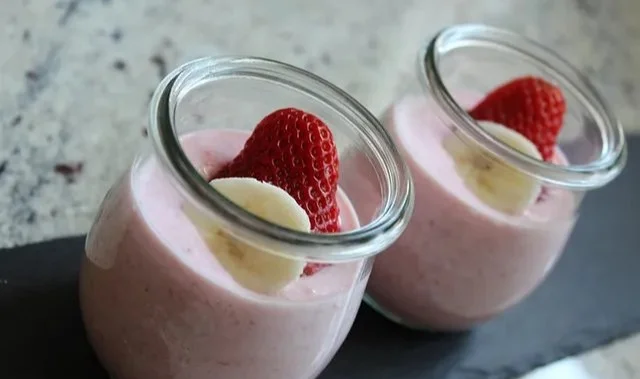Leckerer Joghurt Frühstücks-Smoothie in einem Glas mit frischen Früchten und Haferflocken.