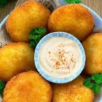 Kartoffelpuffer mit Schinken und Käse auf einem Teller serviert
