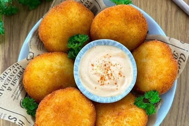 Kartoffelpuffer mit Schinken und Käse auf einem Teller serviert