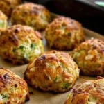 Knusprige Zucchini-Feta-Bällchen frisch aus dem Ofen auf einem Teller.