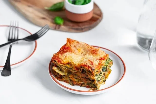 Lasagne mit Spinat und Tomatensauce auf einem Teller serviert.