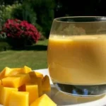 Leckerer Mango-Bananen-Smoothie in einem Glas mit frischen Früchten