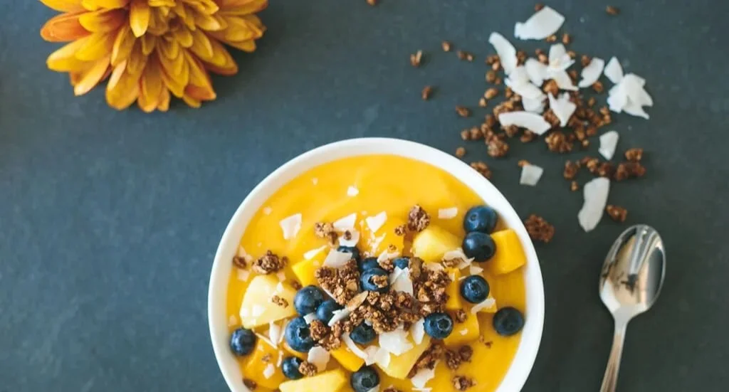 Leckere und gesunde Mango-Smoothie-Schüssel mit frischen Zutaten