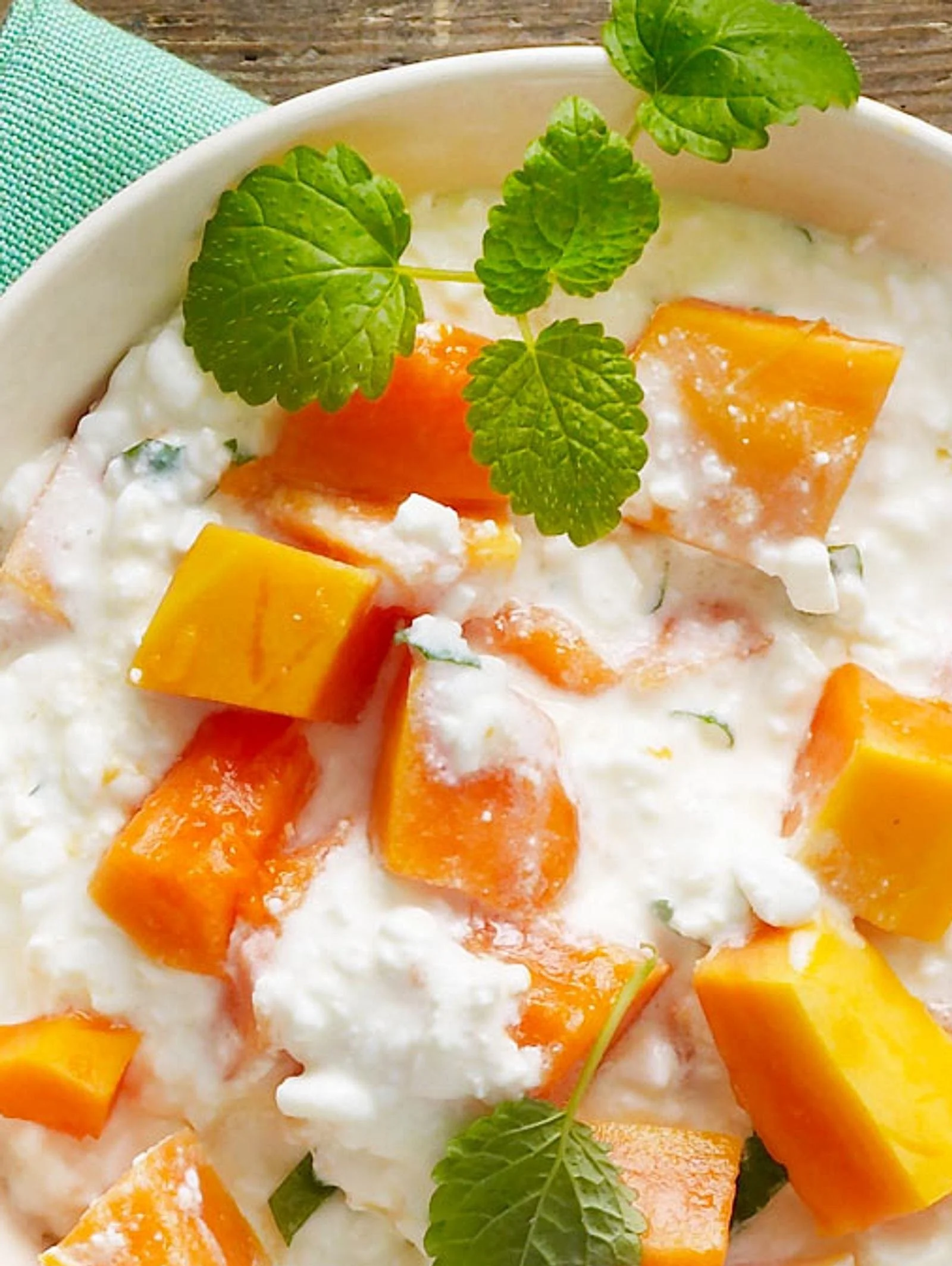 Papaya mit Hüttenkäse serviert in einer Schale, gesundes Frühstück.