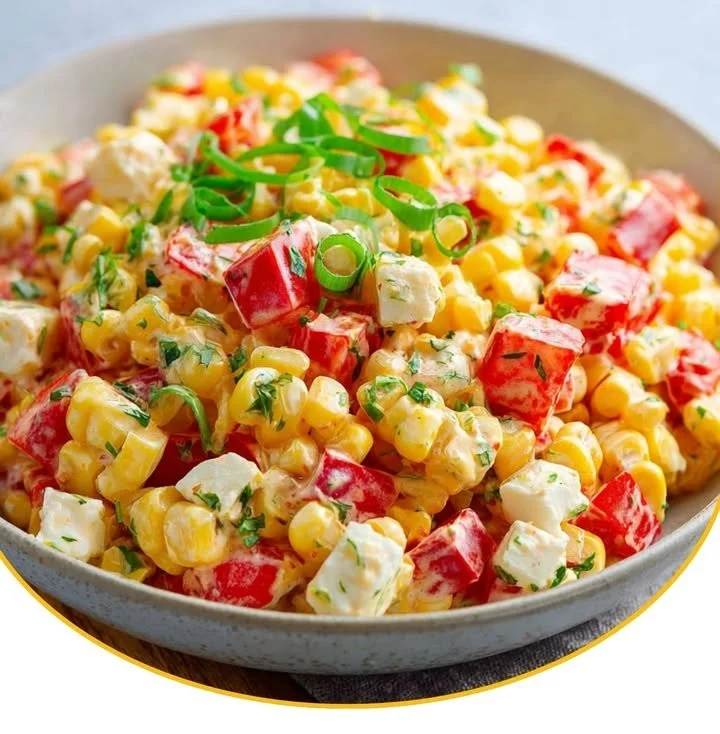 Paprika-Mais-Salat mit Feta und Joghurt auf einem Teller angerichtet