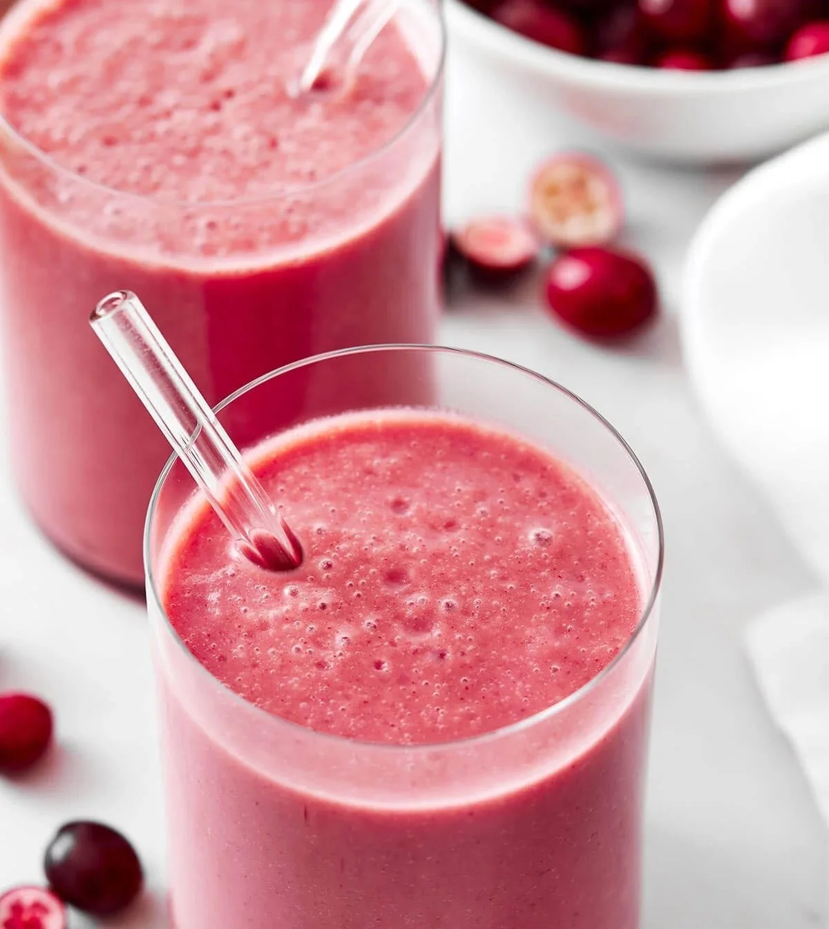 Erfrischender Preiselbeer-Smoothie in einem Glas, garniert mit frischen Preiselbeeren.