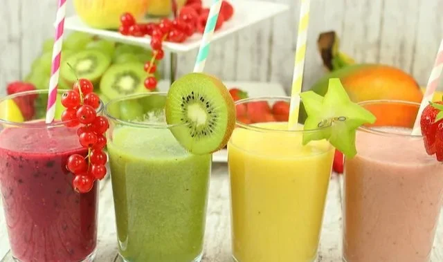 Bunte Smoothie Rezepte mit frischen Zutaten in einem Mixer.