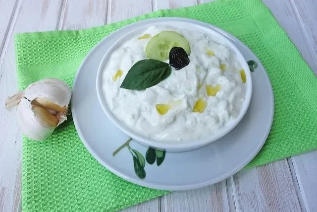 Hausgemachtes Tzatziki Dip mit Gurken und Joghurt auf einem Tisch serviert
