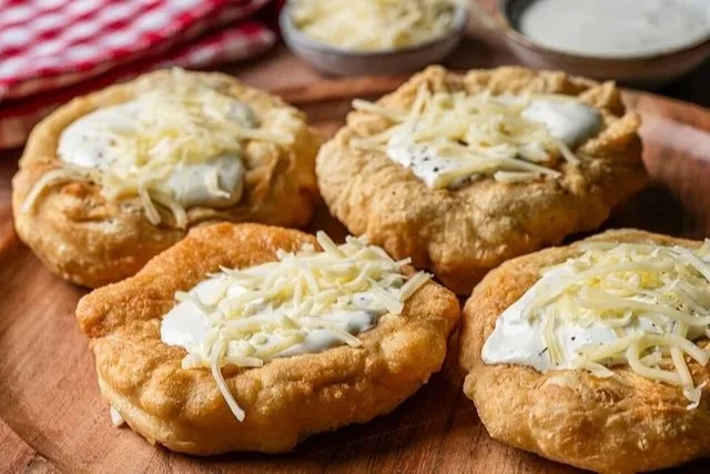 Ungarisches Langos mit Knoblauchcreme und Käse, frisch zubereitet.