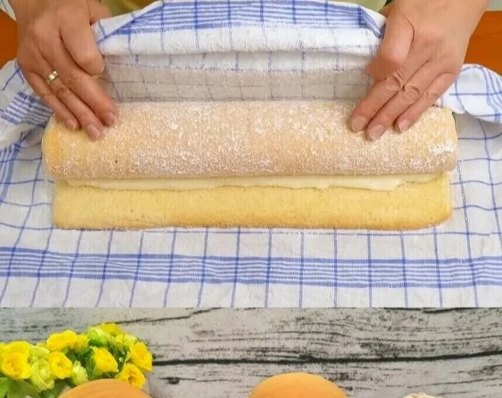 Zitronen-Biskuitrolle mit frischen Zitronenscheiben und einer süßen Füllung