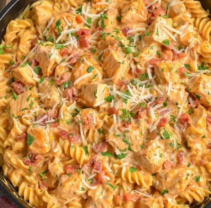 Ein Teller mit Buffalo-Hühnchen-Pasta, garniert mit frischen Kräutern.