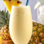 Ein Glas cremige Pina Colada auf einem Tisch am Strand