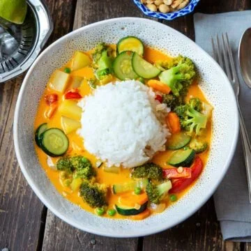 Leckeres Curry mit Reis und buntem Gemüse serviert auf einem Teller