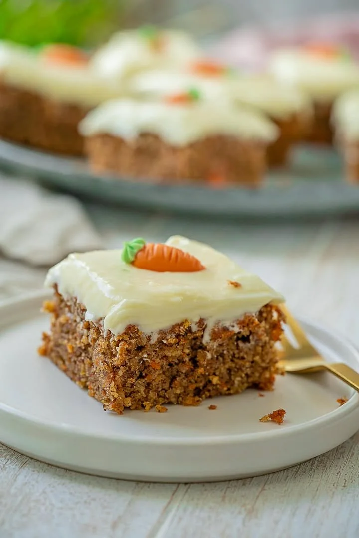 Einfacher glutenfreier Karottenkuchen auf einem Teller, dekoriert mit Nüssen.
