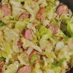 Gebratener Kohl mit Speck, Zwiebeln und Knoblauch in einer Pfanne zubereitet