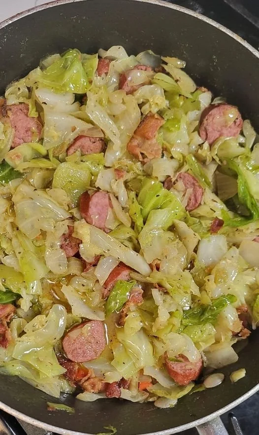 Gebratener Kohl mit Speck, Zwiebeln und Knoblauch in einer Pfanne zubereitet