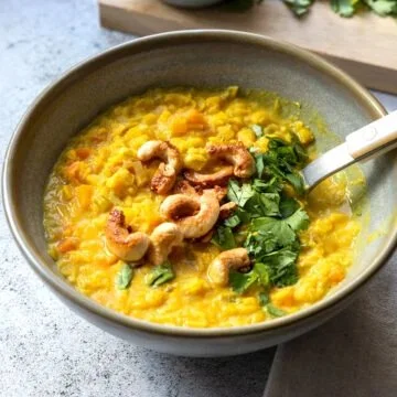 Schüssel mit aromatischem Gelber Linsen Dal, grünem Koriander und Gewürzen.