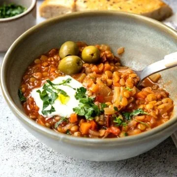 Griechische Linsensuppe serviert in einer Schüssel mit frischen Kräutern