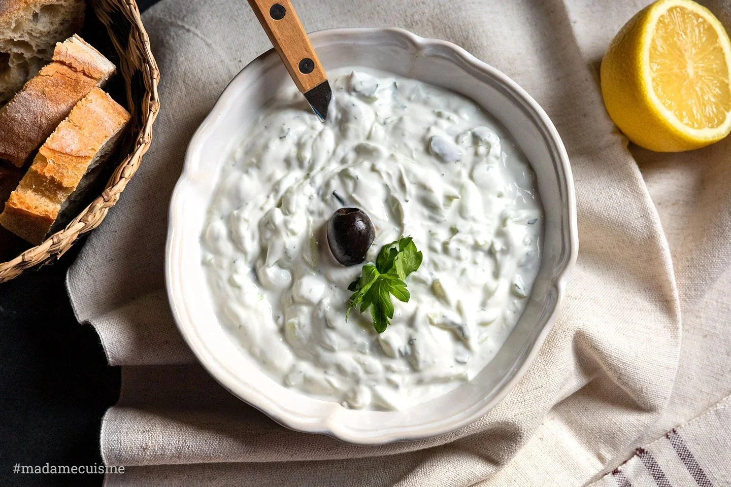 Selbstgemachtes griechisches Tsatsiki in einer Schüssel mit frischen Zutaten