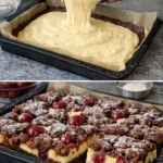 Hermann-Kirsch-Zupfkuchen auf einem Teller, dekoriert mit frischen Kirschen.