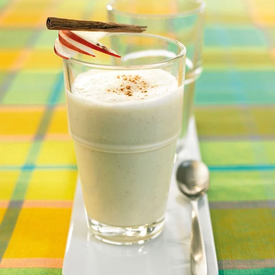 Ingwer gewürzter gebackener Apfelsmoothie in einem Glas mit Apfelscheiben.