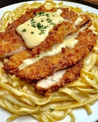 Knuspriges Hähnchen mit cremiger Pasta auf einem Teller serviert